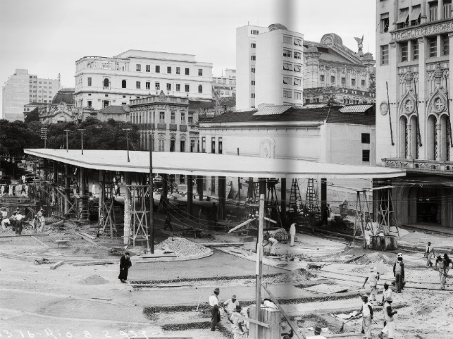 Obras no antigo terminal de bondes no Largo da Carioca, conhecido como o Tabuleiro da Baiana, 8 de fevereiro de 1939 / Achados e Perdidos, página. À direita, o prédio do Liceu Literário Português e a escultura da águia do Teatro Municipal